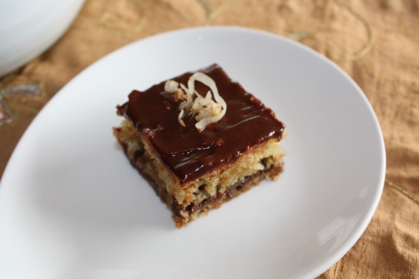 Top view of chocolate chip coconut bar on white plate.