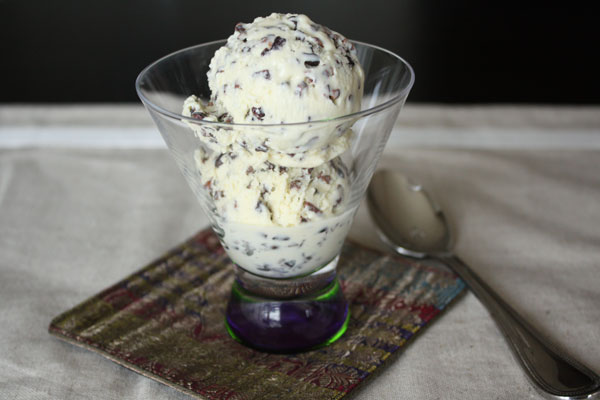 Two scoops of White Chocolate Cocoa Nib Ice Cream in a small stem maritini glass.