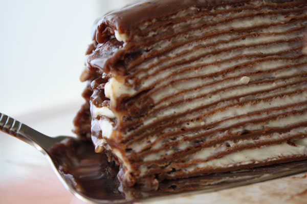 Close up of crepe layers in a slice of hazelnut chocolate crepe cake. 