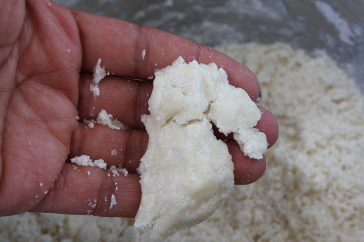 Hand showing consistency of finish pie dough.