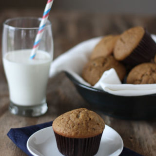 Chocolate chip espresso muffin in plate with glass of milk.