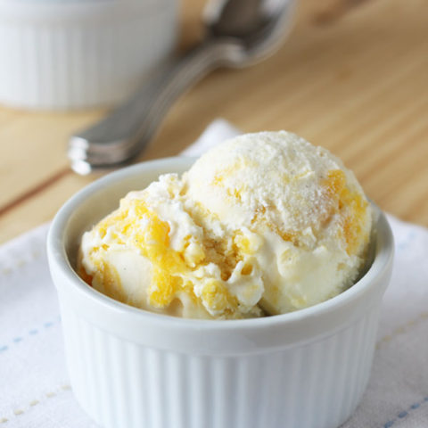 Mango swirl ice cream in a white bowl.