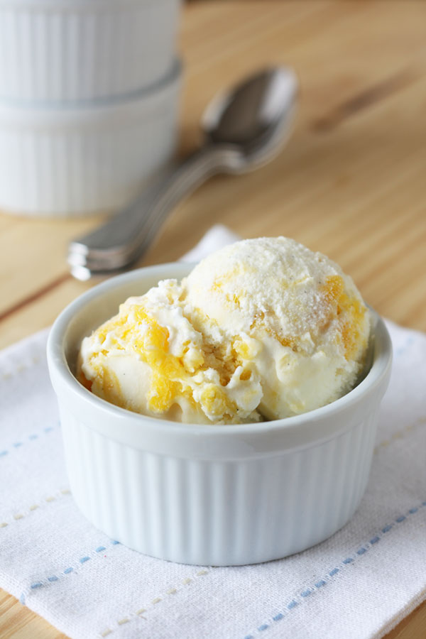 Mango swirl ice cream in a white bowl.