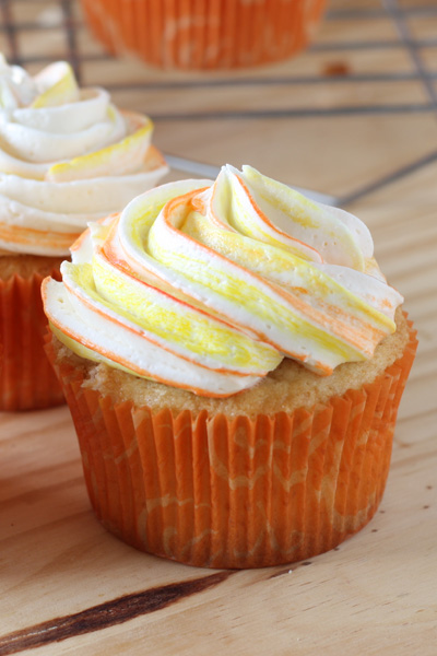 Mango Cupcakes with swirl colored frosting in a plate