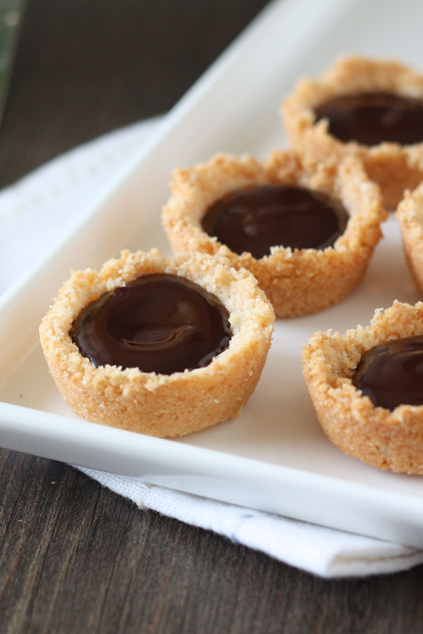 Mini coconut ganache pies in white tray.