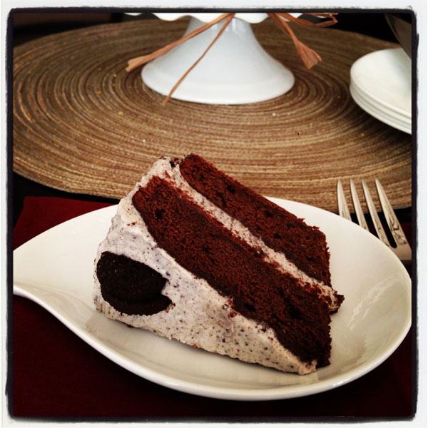 Slice of cookies and cream chocolate cake on white plate.