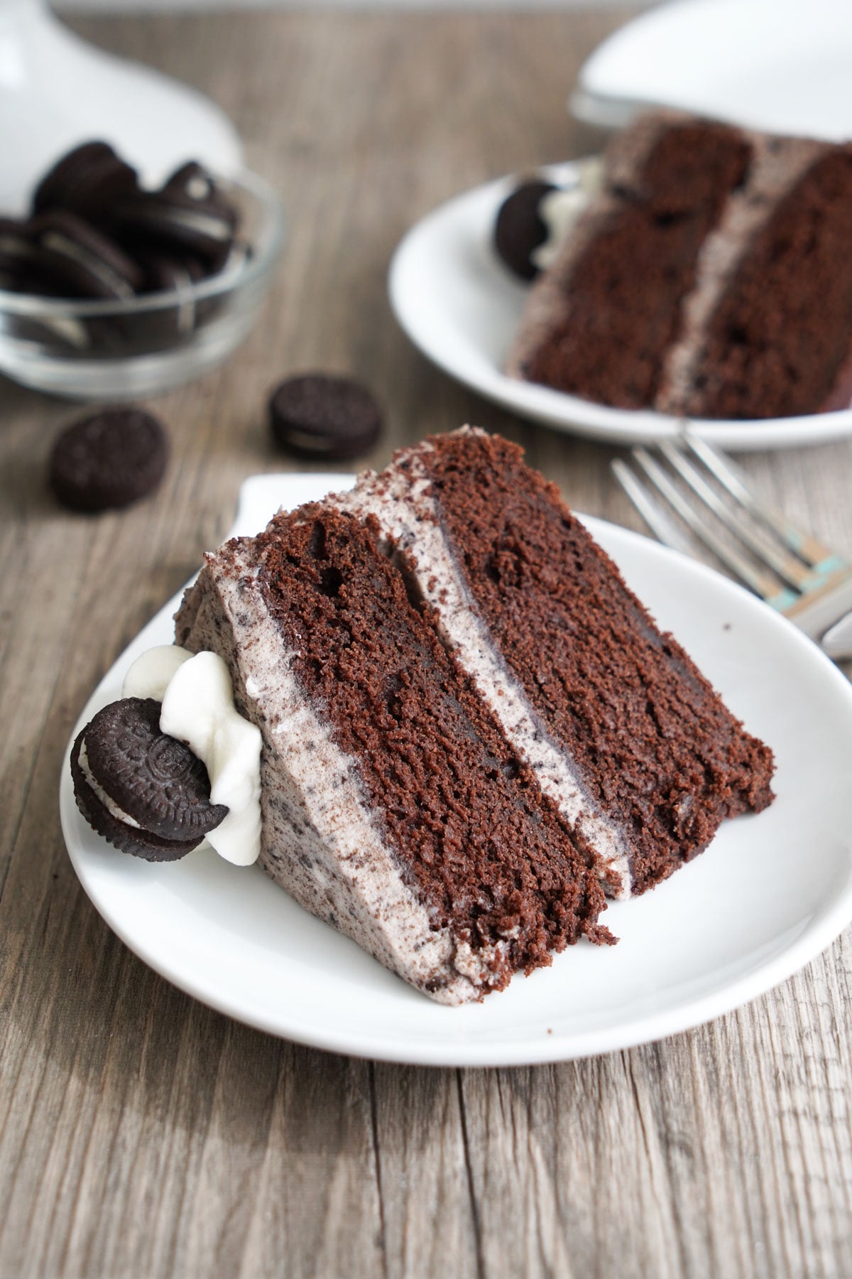 Slice of six inch chocolate Oreo cake showing two chocolate layers and cookies and cream filling