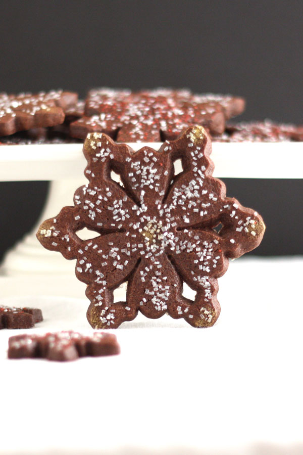 chocolate peppermint snowflake cookie with cookies on pedestal in background