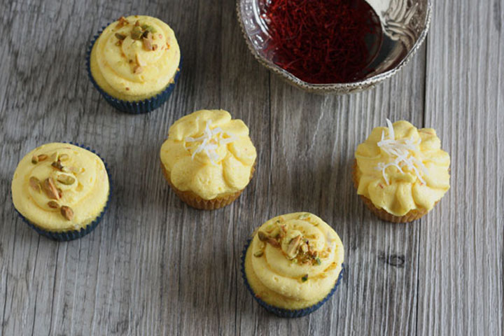 Top view of five saffron cupcakes and bowl full of saffron threads. 