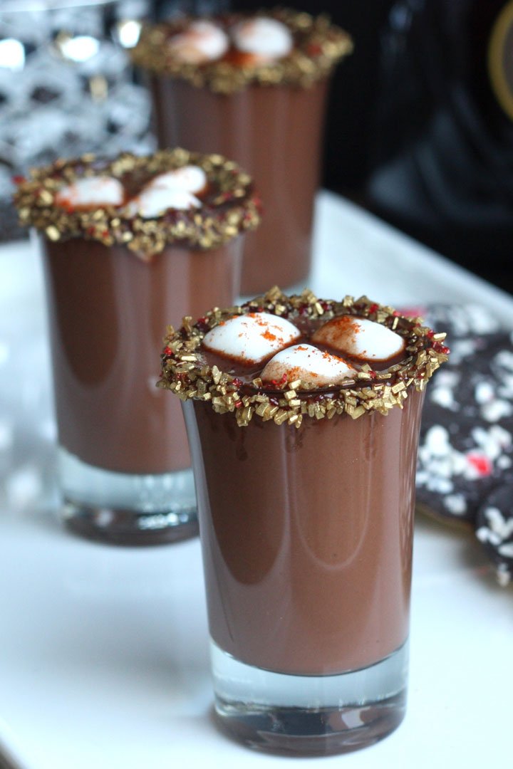 Close up of Mexican hot chocolate shots with peppermint cookies in background.