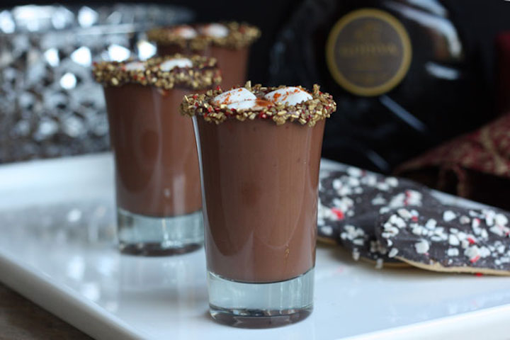 Mexican hot chocolate shots in white tray with cookies in background.