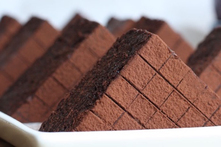 Triangle shaped brownies lined up in a white tray.