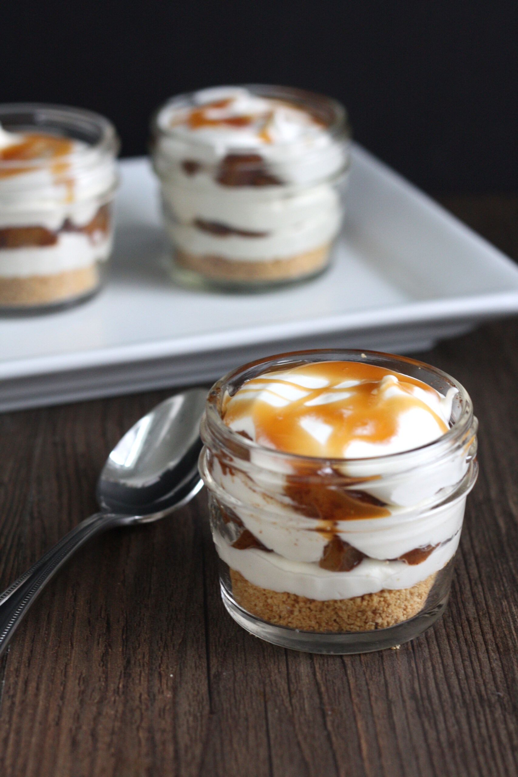 Apple pie cheesecake jar with whipped cream flattened out so the jar is closable.
