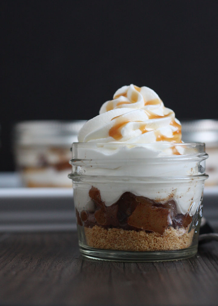 Apple Pie Cheesecake Jars- graham crackers layered with cooked spiced apples and cheesecake and whipped cream. A quick recipe that's as easy as pie!