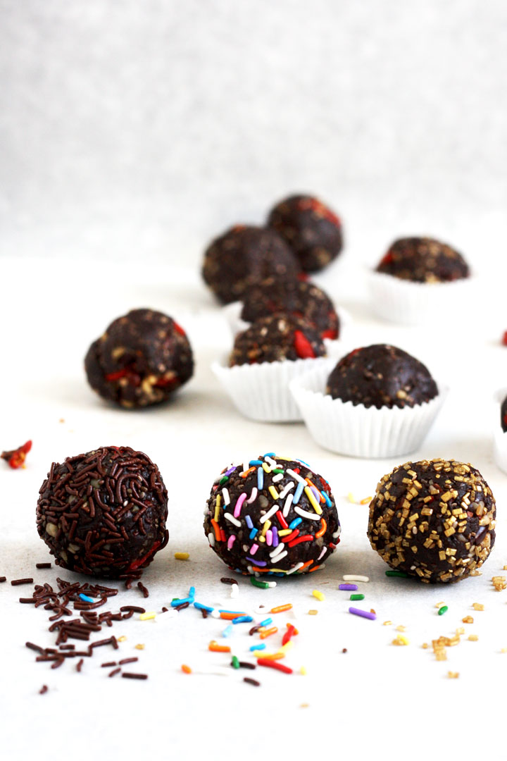 No bake healthy brownie balls rolled in chocolates spirnkles, rainbow sprinkles and gold sugar crystals.