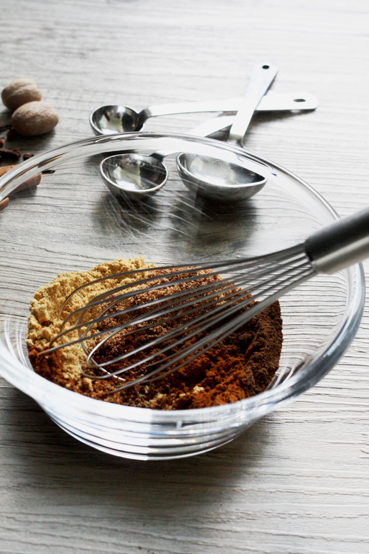 Ground spices making up pumpkn spice being whisked to gther in glass bowl.