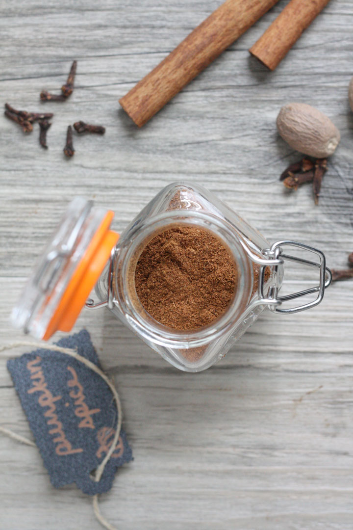 Top view of open jar of pupmkin spice with labeled tag on the side.