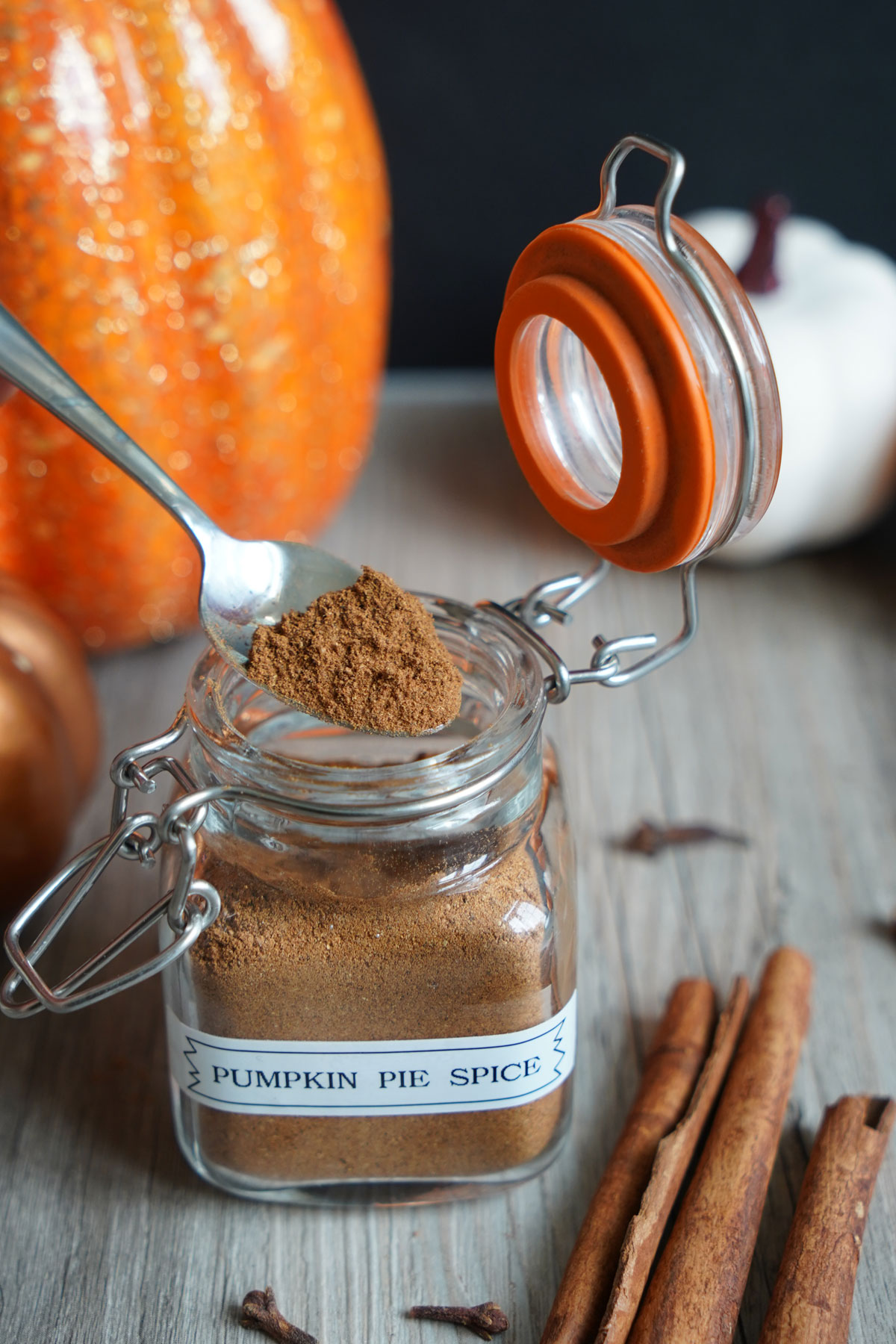 Pumpkin pie spice being spooned out of jar.