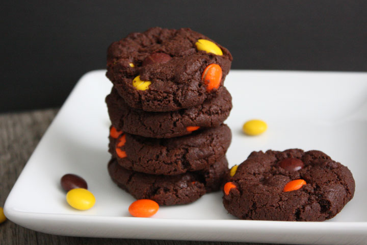 Stack of Reese's Pieces double chocolate cookies in white plate. 