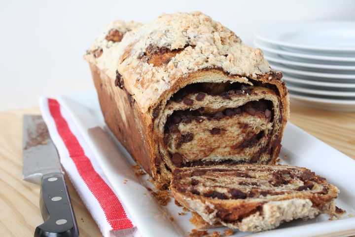 Chocolate Babka loaf with one slice cut off the end in large white platter