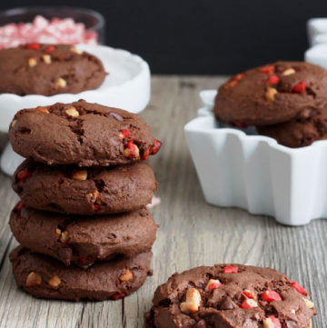 Stack of chocolate peppermint cake mix cookies and one cookie by itself on wood board.