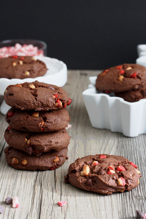 Stack of chocolate peppermint cake mix cookies and one cookie by itself on wood board.