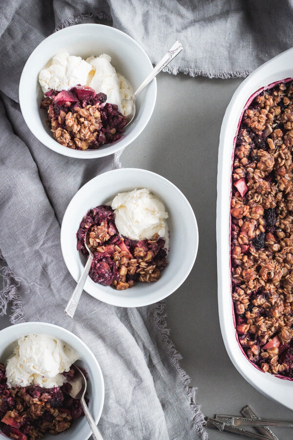 Blackberry apple hazelnut crisps served in white bowls.