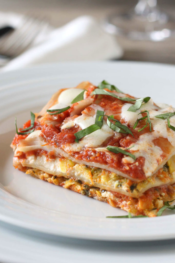 Slice of vegetable lasagna on white plate.