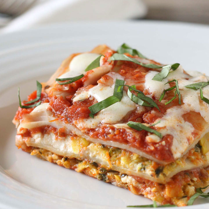 Slice of vegetable lasagna on white plate.