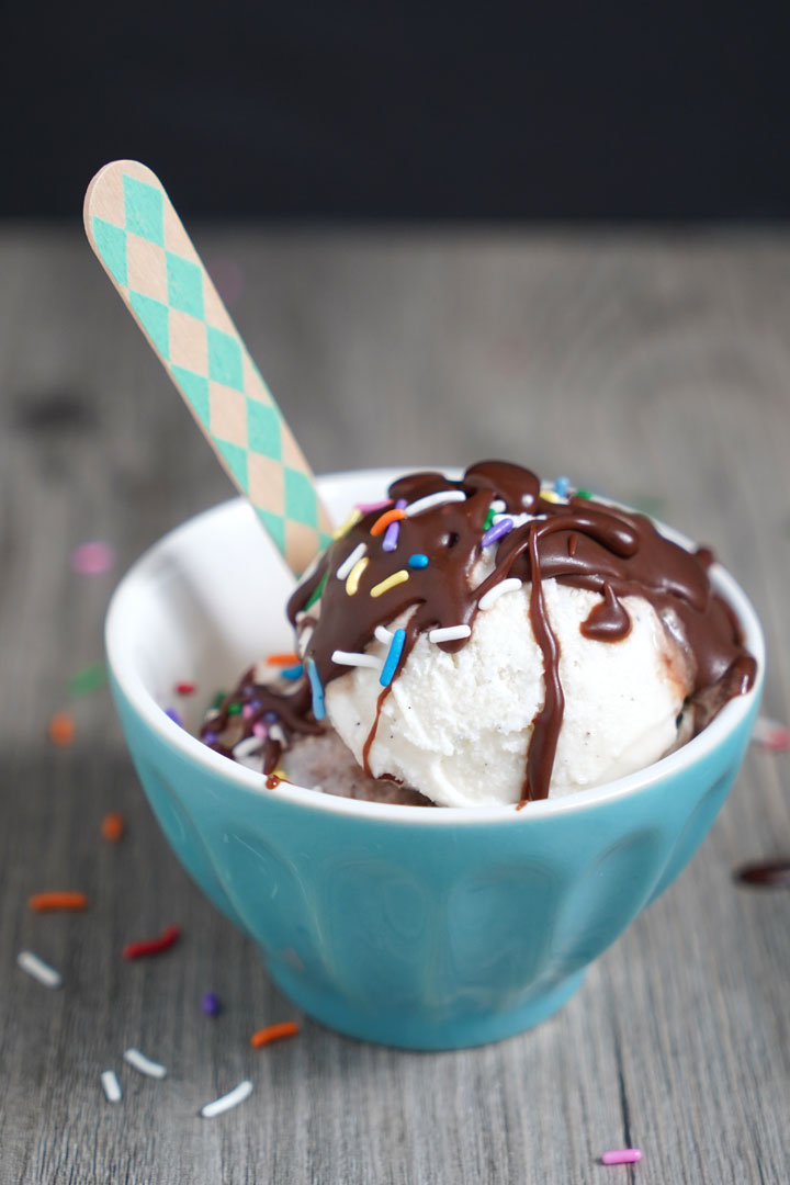 Ice cream in a blue bowl, drizzled with chocolate sauce and sprinkles. 