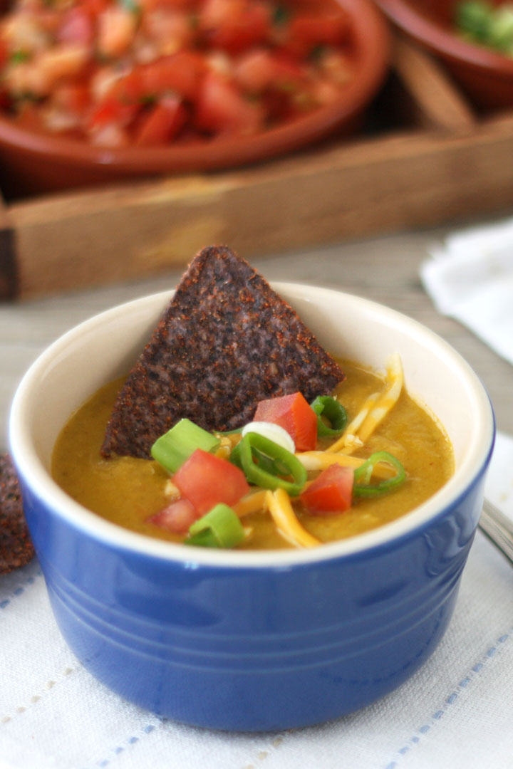 Close up view of corn soup in blue bowl on white napkin.