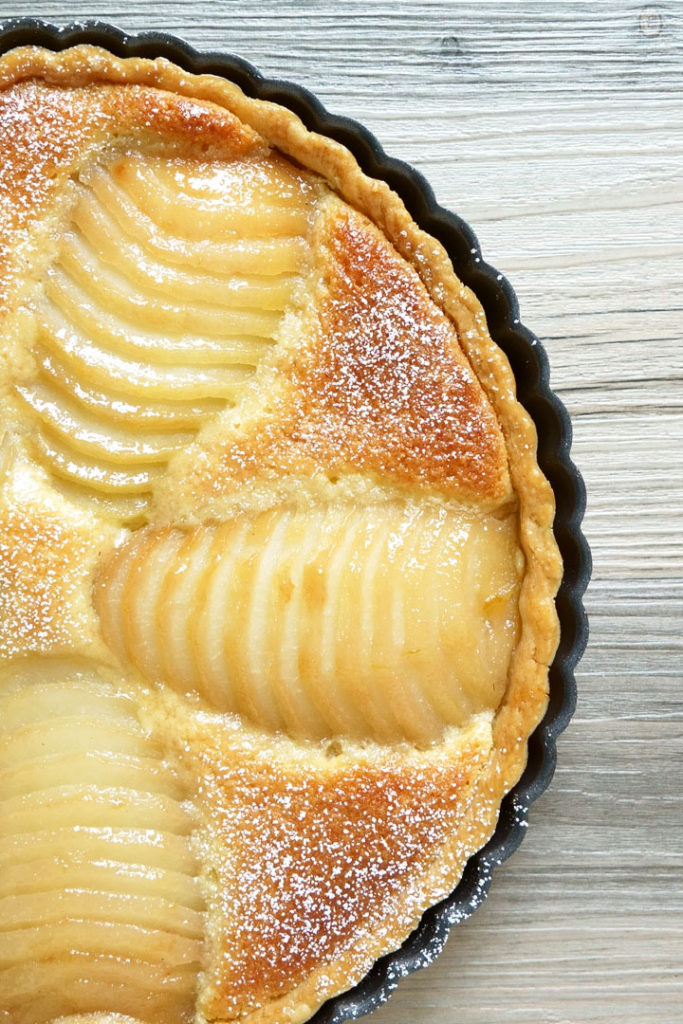 Gekochte Tarte mit Birnen und Frangipane mit einer auf die Birnen aufgetragenen Glasur.