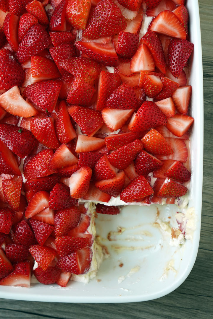 Top view of strawberry tiramisu in casserole dish with slice cut out. 