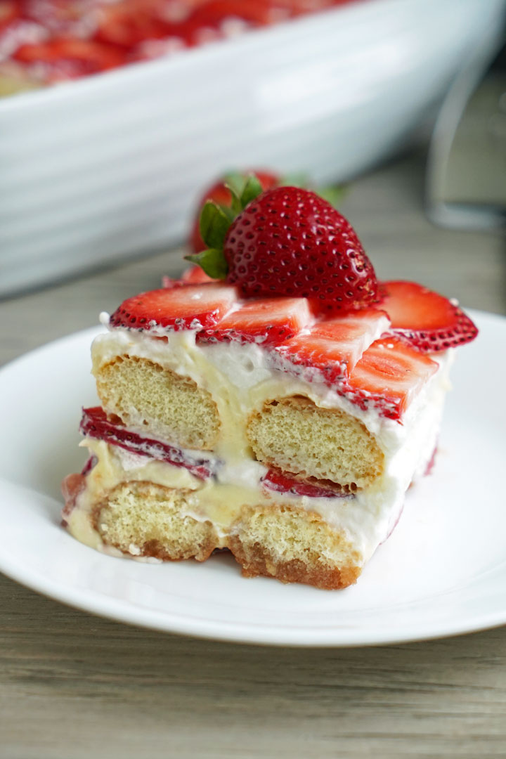 Close up of slice of strawberry tiramisu on a white plate. 