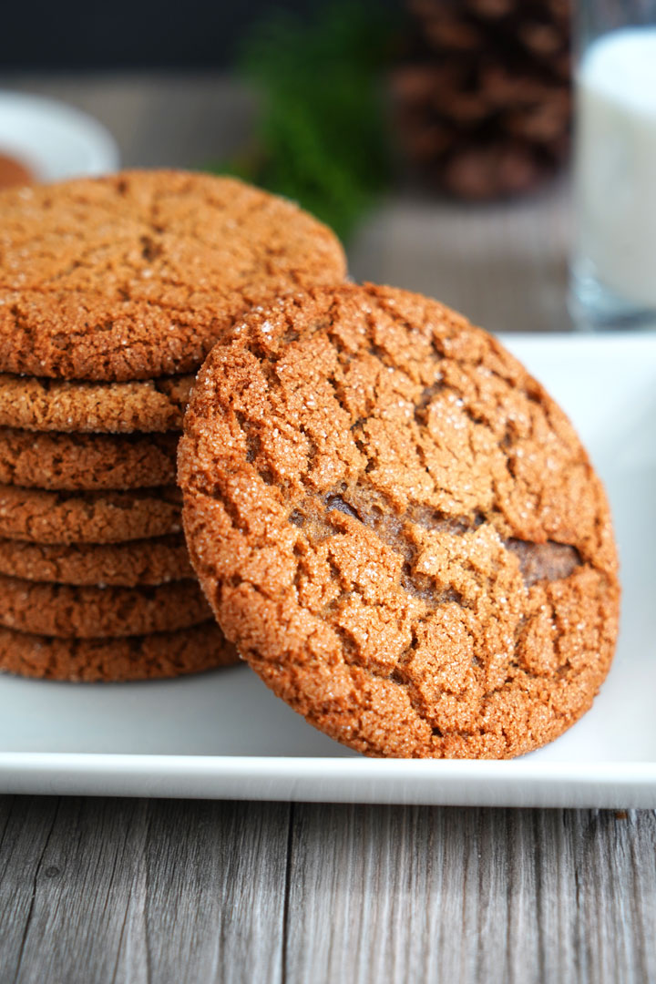 Close up view of gingersnap cookie and stack of gingersnap cookies.
