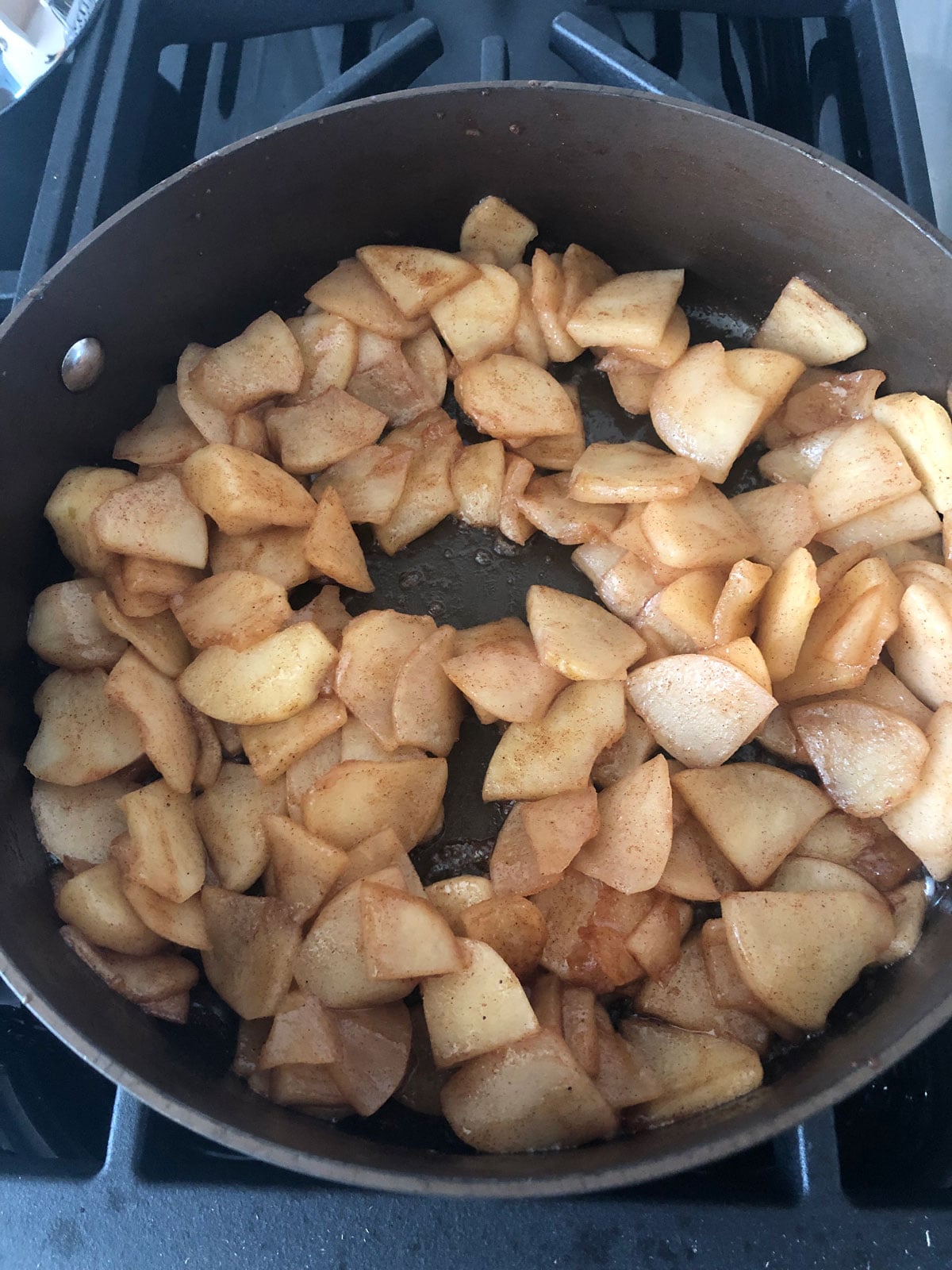 Thinly sliced apples cooked down with brown sugar and warm spices in a skillet for the filling.