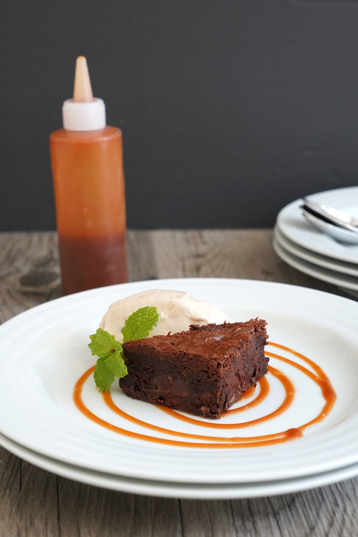 Plated brownie with ices cream using caramel sauce for decoration.