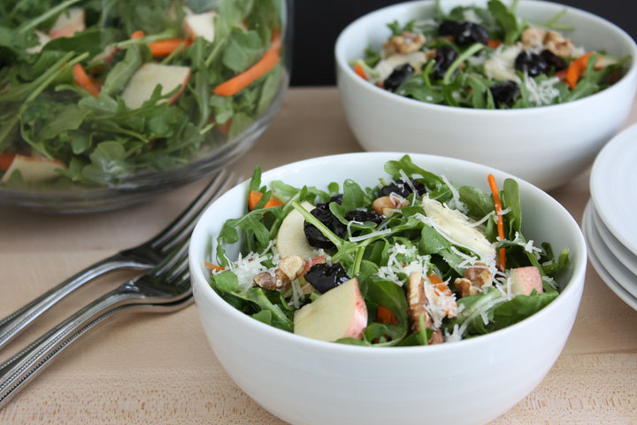 Fall and arugula apple salads in white bowls with forks.