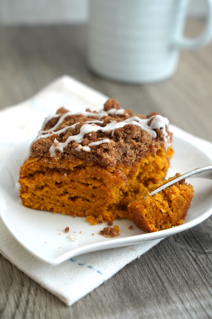 Pumpkin coffee cake piece on a white plate with fork.