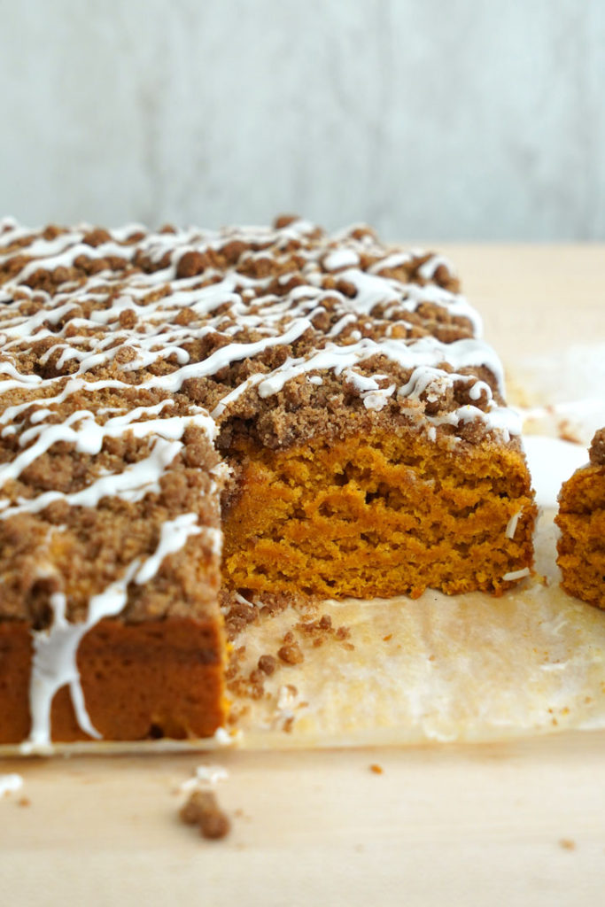 Pumpkin coffee cake with piece cut out of corner.