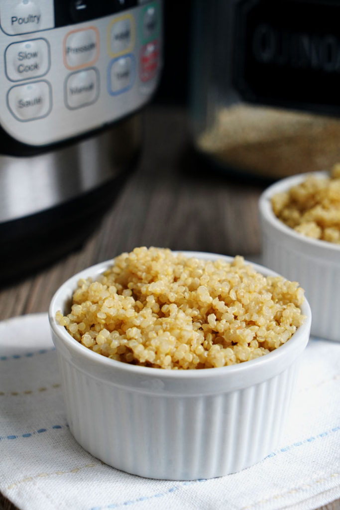 Fluffy quinoa in a white ramekin with Instant Pot in background.