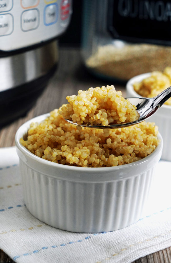 Spoonful of cooked, fluffy quinoa.
