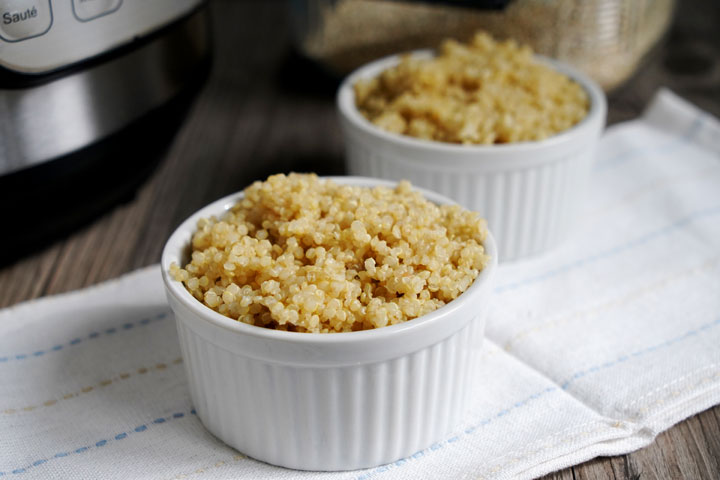 Fluffy quinoa in a white ramekin with Instant Pot in background.