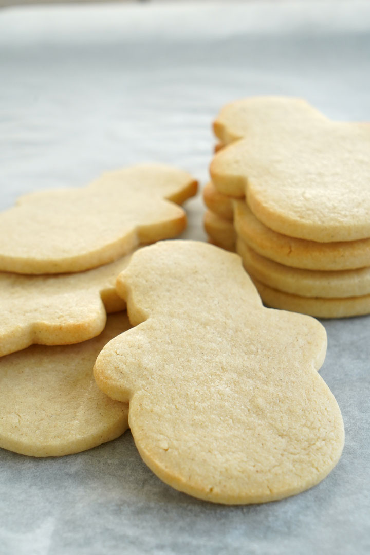 Baked, unfrosted snowman shaped sugar cookies.