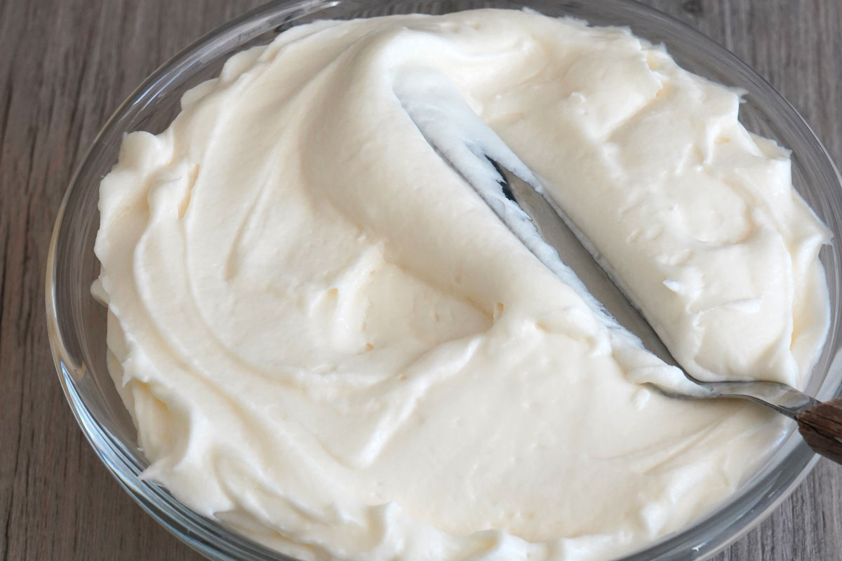 Frosting in bowl with offset spatula.