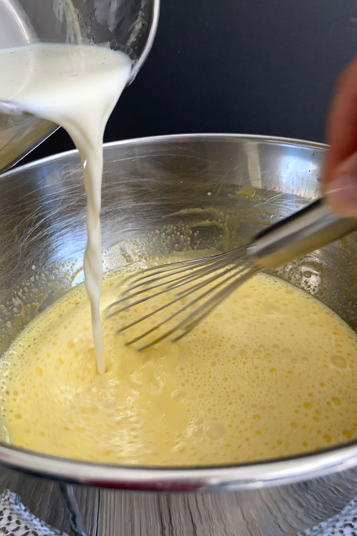 Egg yolks being tempered with hot milk mixture.