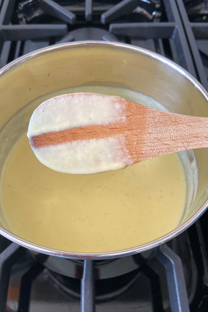 Wooden spoon test for checking cooked cream.