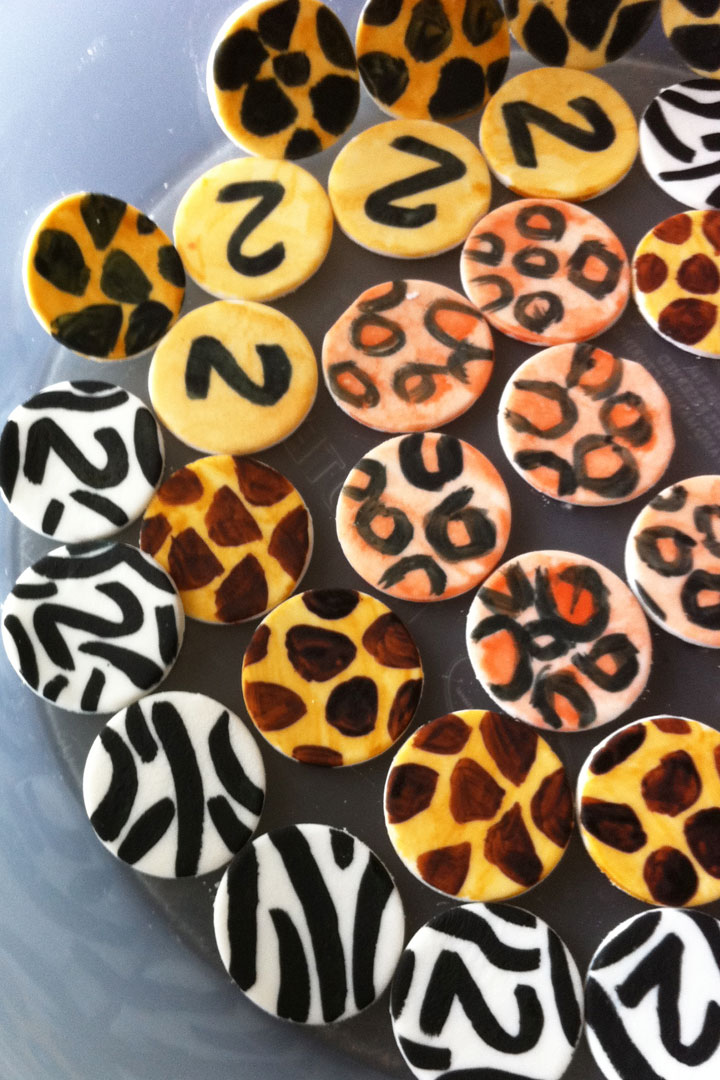 DIY cupcake toppers made with fondant and painted with safari jungle animal themed designs.