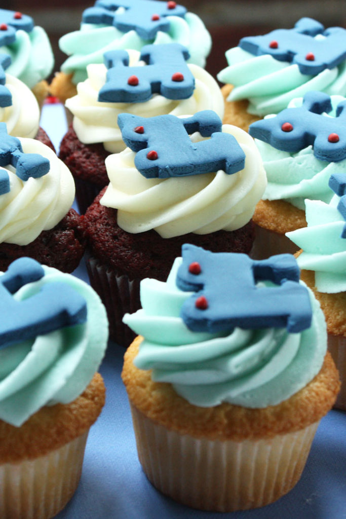 Edible train shaped cupcake toppers made of fondant on vanilla and chocolate buttercream cupcakes.