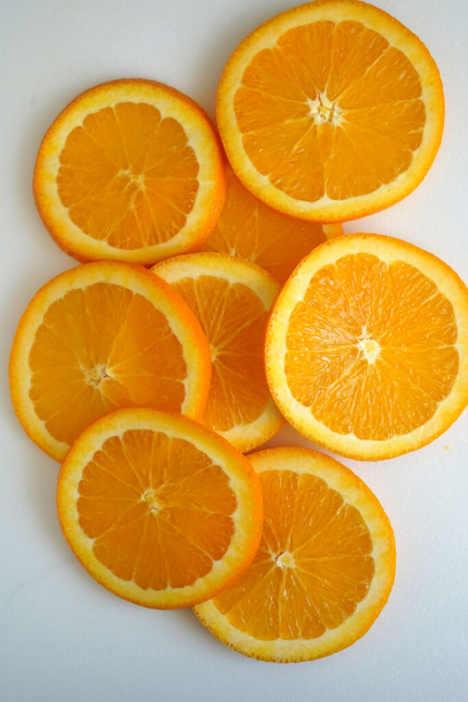 Round orange slices on a white cutting board.